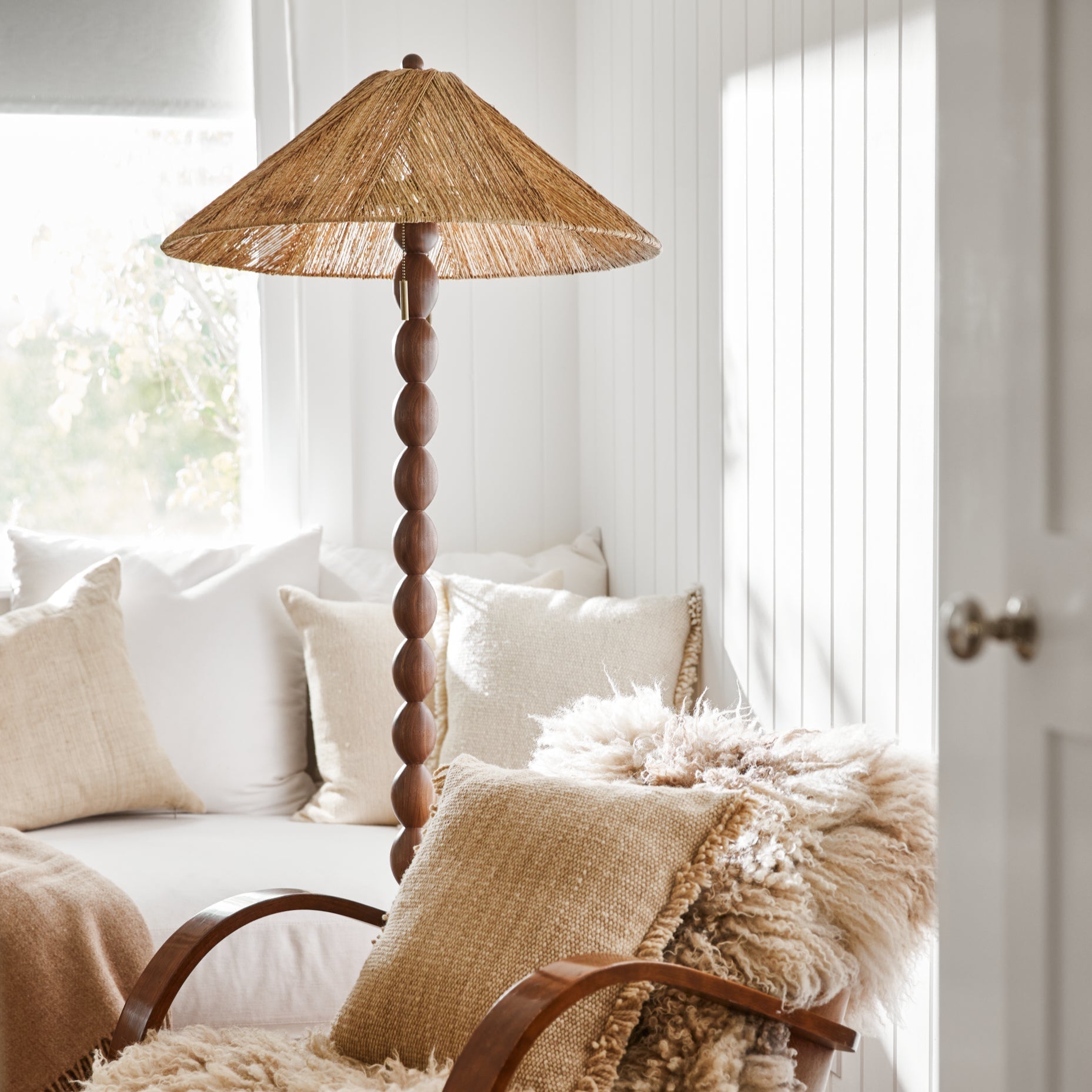 jute and wood lamp next to arm chair and white couch