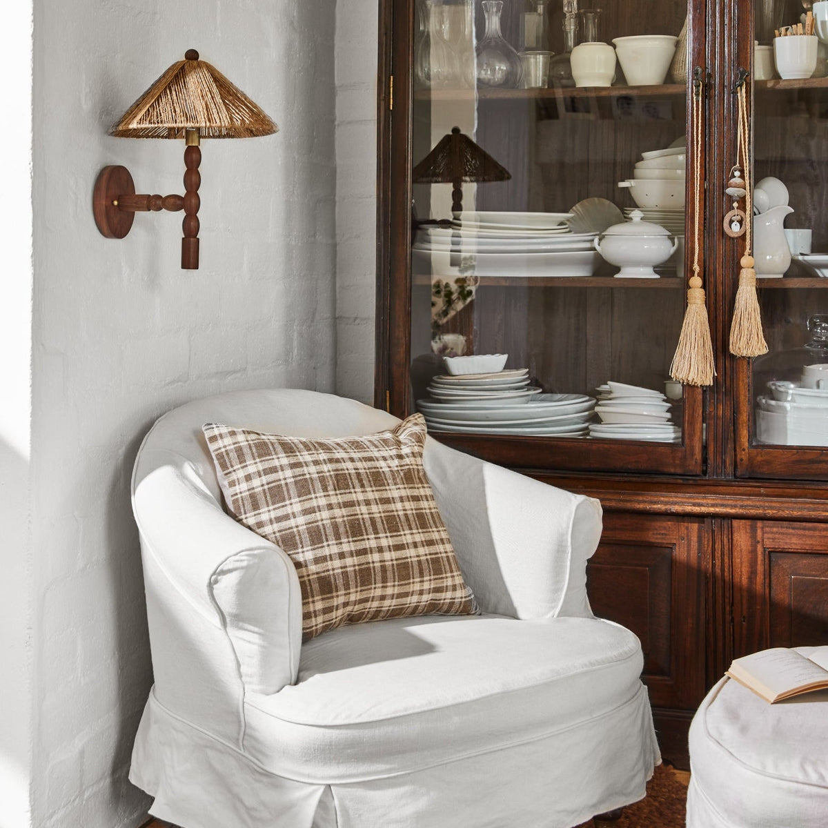 sconce hanging on white wall next to white lounge chair