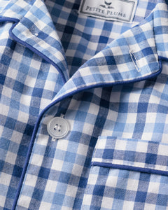 Close-up of a blue and white gingham patterned shirt from the Kids Twill Pajama Short Set in Royal Blue Gingham. It includes buttons, a pocket with piping detail, reflecting luxurious sleepwear charm. The neck label reads Petite Plume.