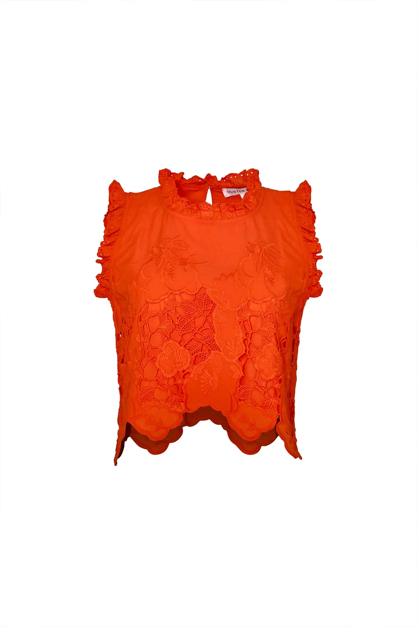 The Francesca Top is a sleeveless top with cutout embroidery and a cropped profile.