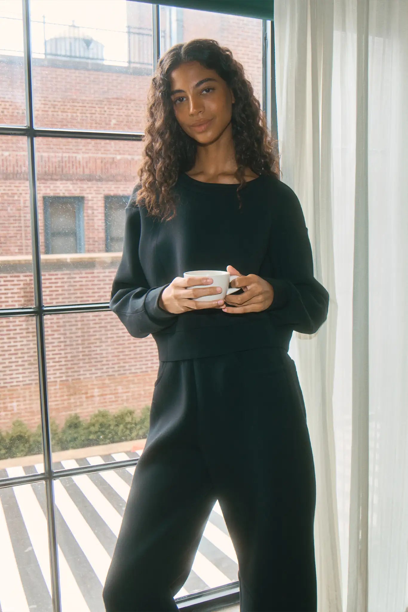 The Jennie Sweatshirt is a structured scuba in deep Onyx with pleated long sleeves.