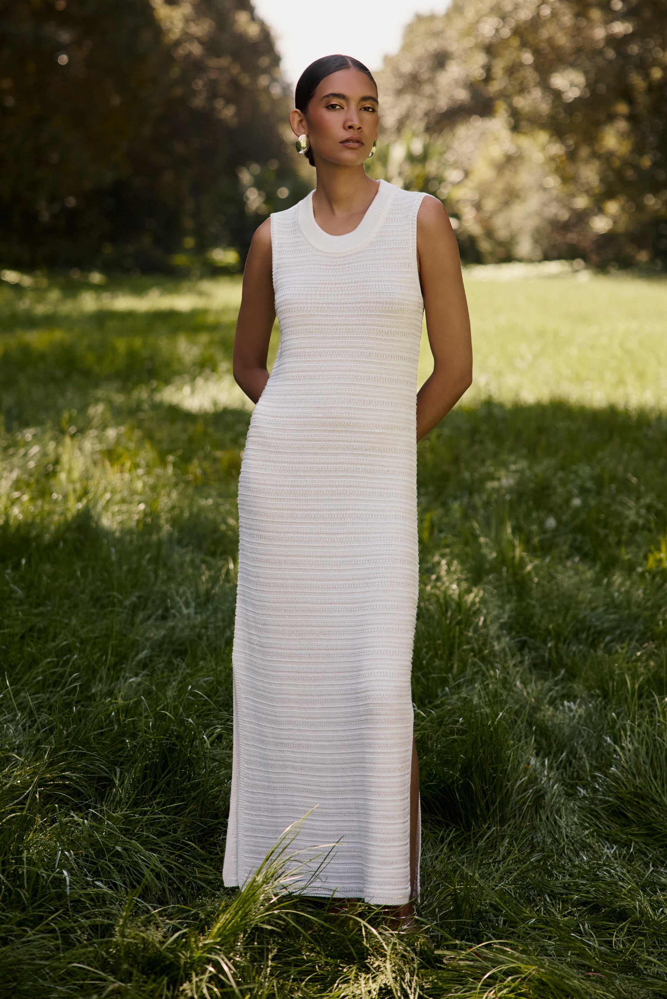 Sleeveless white midi dress with a fitted silhouette and textured knit fabric