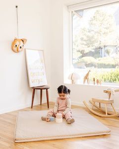 baby girl playing on a play mat