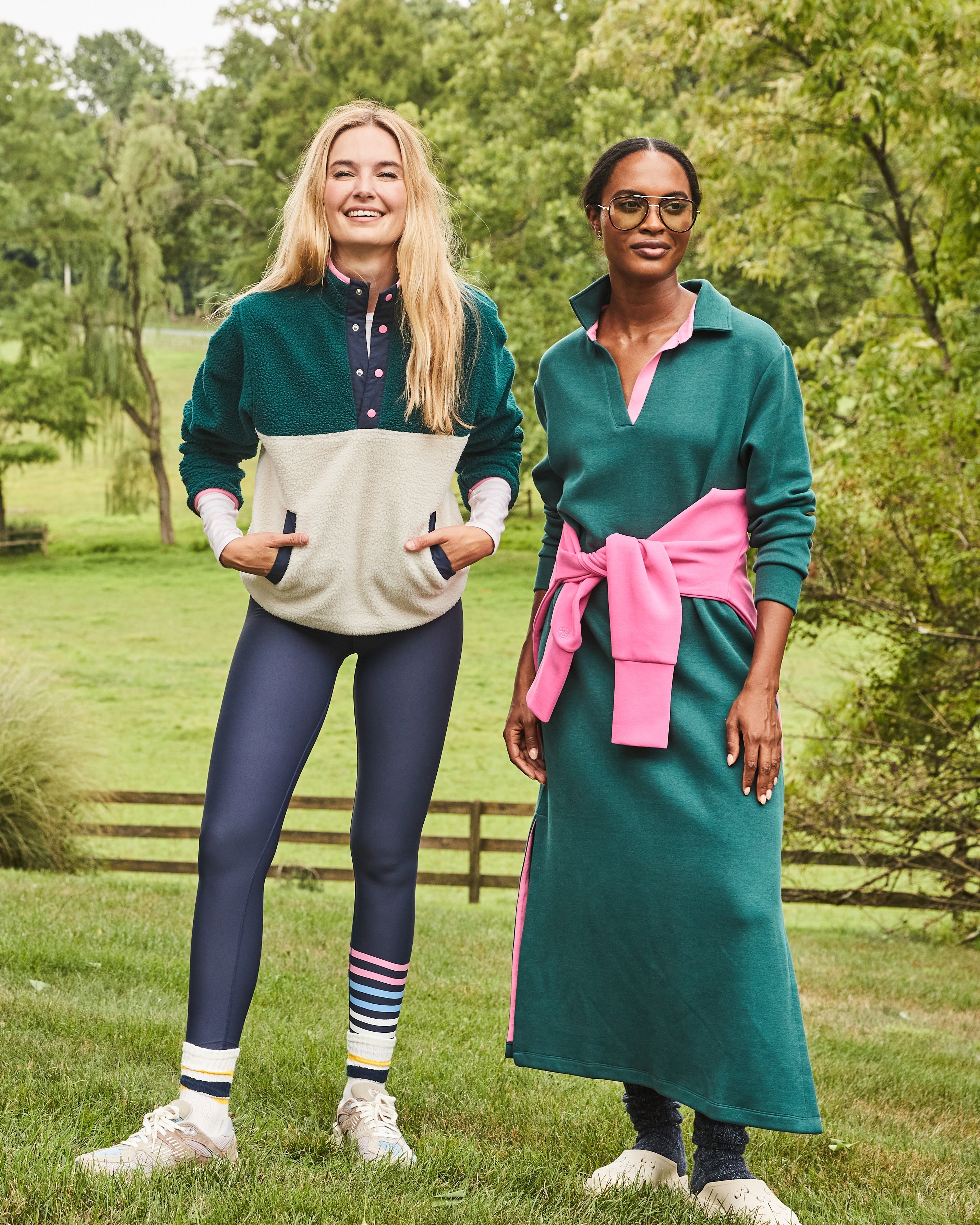 Model left  is wearing the Academy Sherpa in Ivy/ Cream over the Everyday Long Sleeve in Super White/ Peony Stripe and the Everyday Legging in Navy Peony/ Matisse Stripe. Model right is wearing the Beck Dress in Ivy with the Everyday Pullover in Peony tied around her waist.