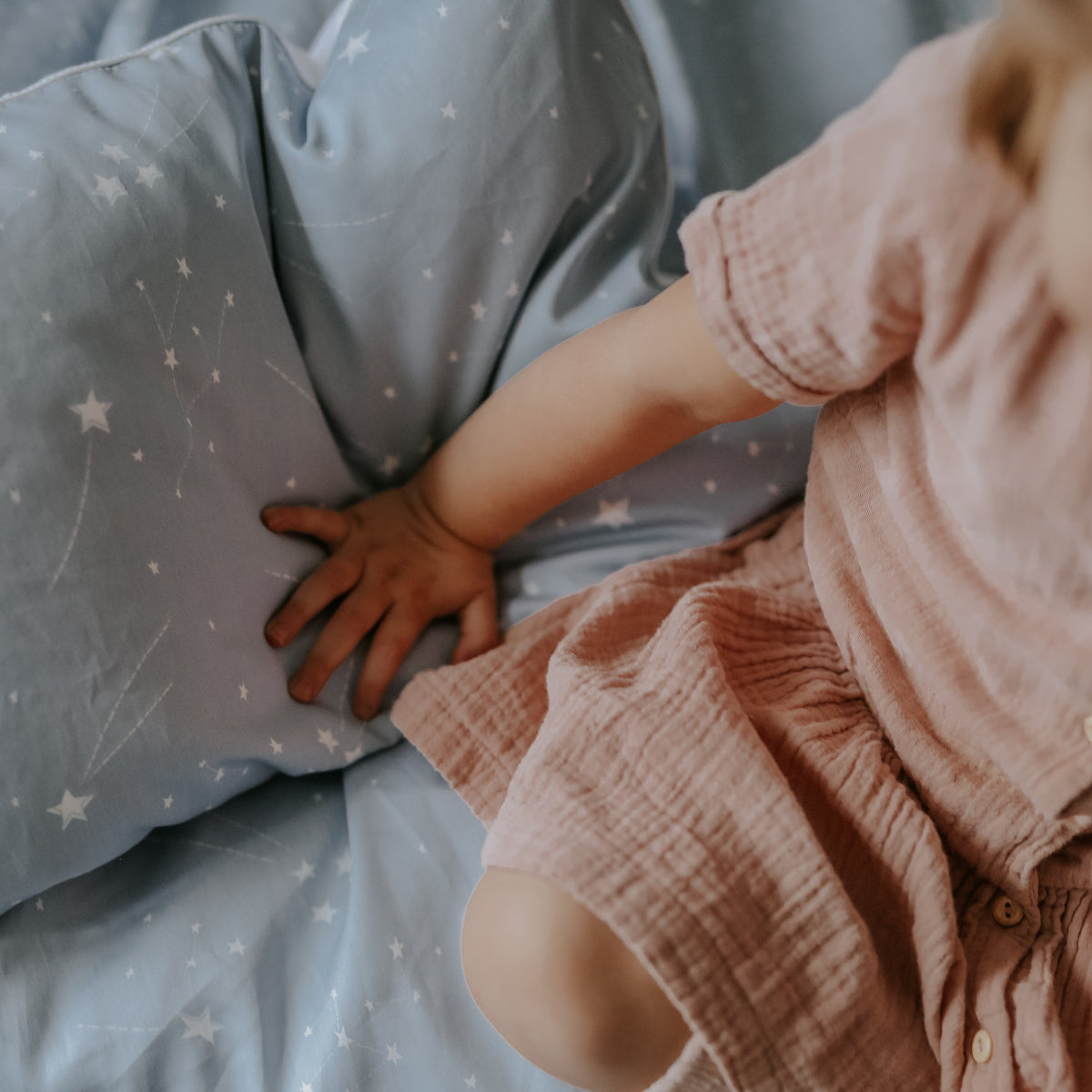 Toddler playing with the Toddler Pillow in the "Once Upon A Time" print in blue