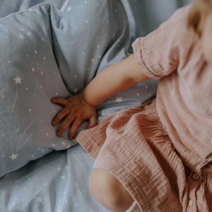 Toddler playing with the Toddler Pillow in the "Once Upon A Time" print in blue