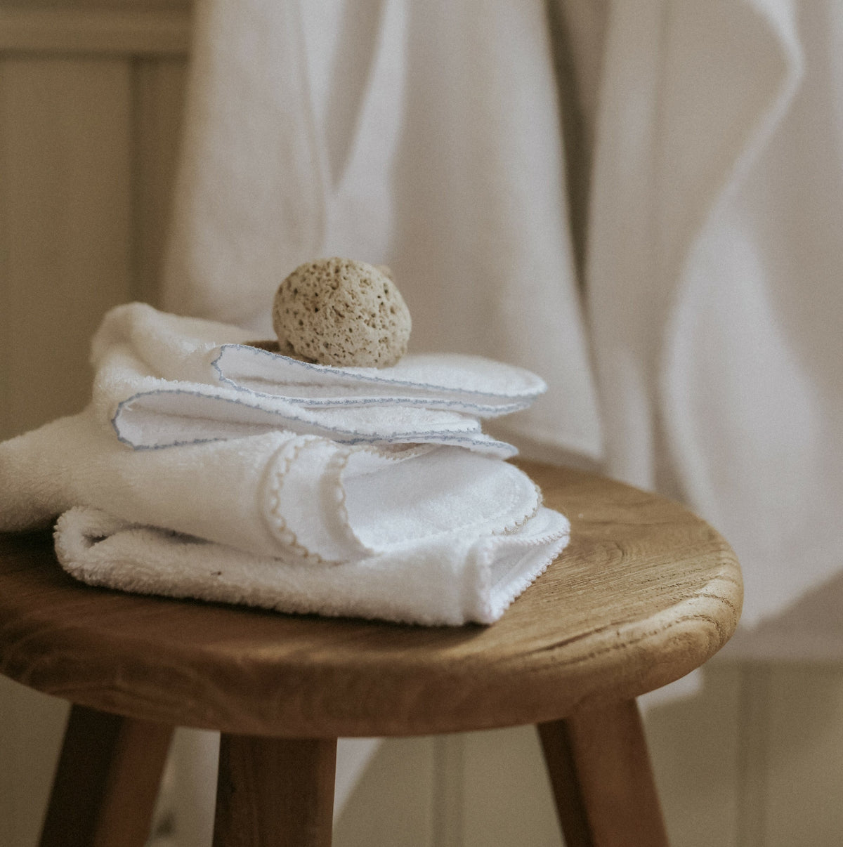 Classic Washcloths folded on top of wood stool 