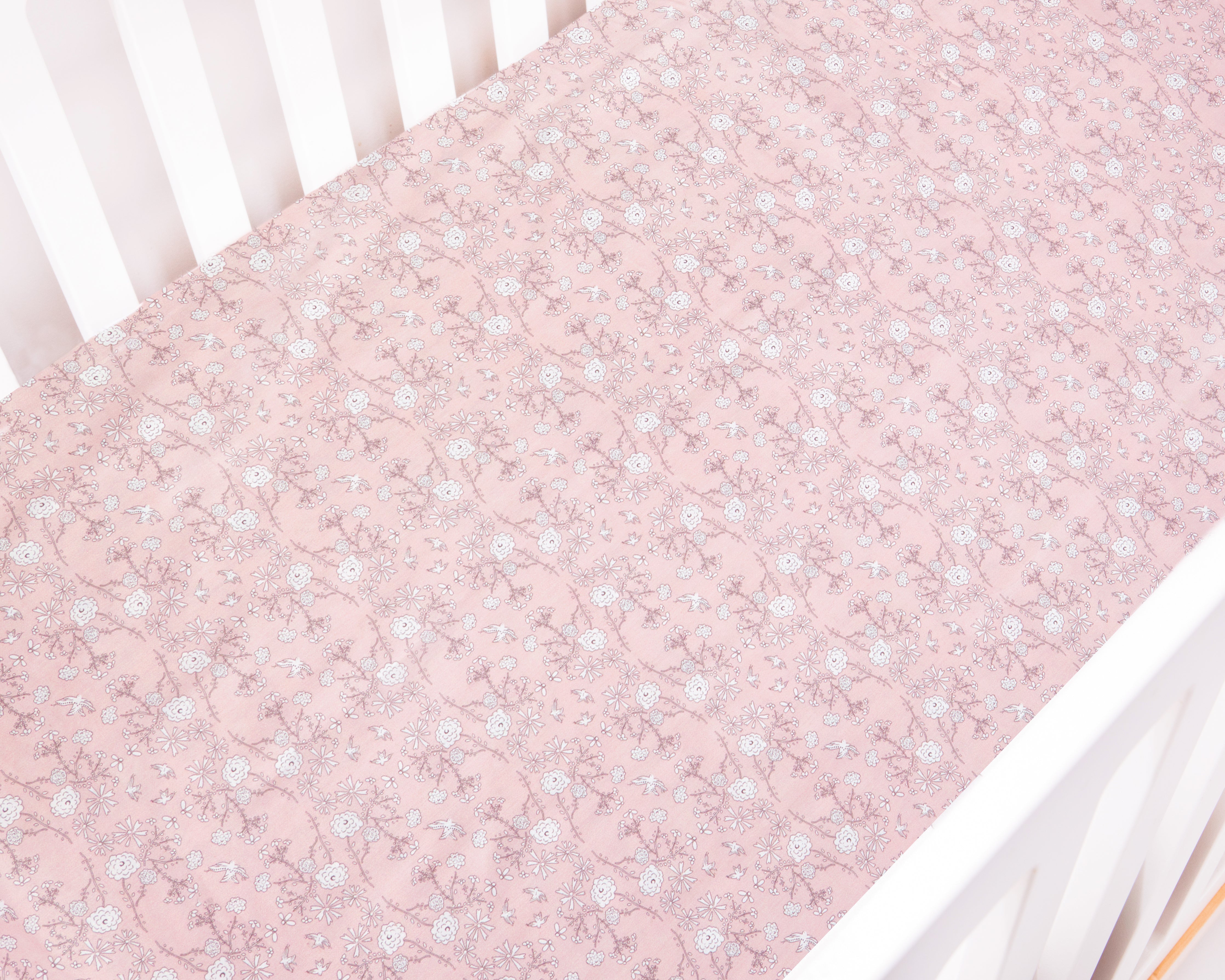 Bird's Song in Pink laid on a Crib Sheet