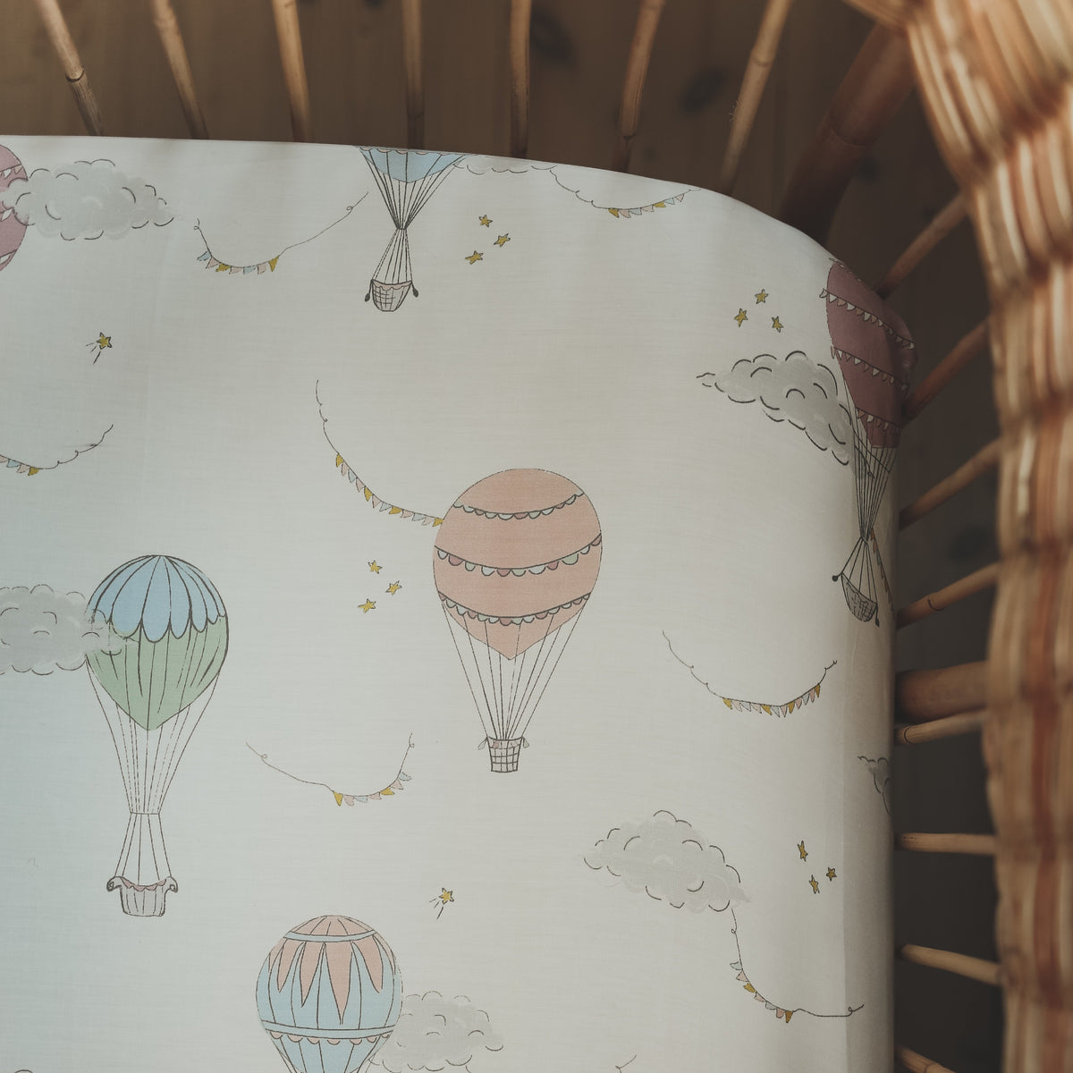 Crib Sheet in "Touch The Sky" print in the color pink featured in a crib