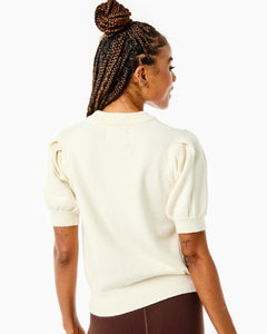 Model is wearing the Locust Active Sweater in Cream with the University Flare Pants in Chocolate